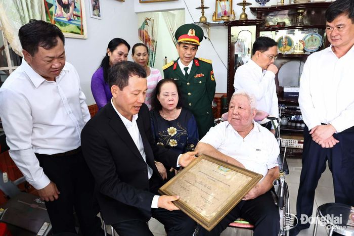 Đồng chí Vũ Hồng Văn, Ủy viên Trung ương Đảng, Bí thư Thành ủy, Trưởng đoàn Đại biểu Quốc hội thành phố trò chuyện với Anh hùng Lực lượng vũ trang nhân dân Trần Văn Chín. Ảnh: Công Nghĩa