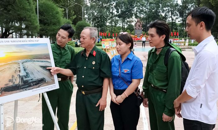 Cựu chiến binh và đoàn viên, thanh niên phường Tam Hiệp xem triển lãm ảnh tại buổi họp mặt. Ảnh: Nguyệt Hà