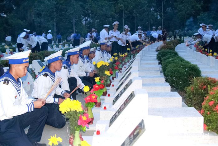 Đoàn viên thanh niên và cán bộ, chiến sĩ các đơn vị lực lượng vũ trang trên địa bàn thành phố thắp hương, thắp nến trên từng phần mộ liệt sĩ. Ảnh: Nga Sơn