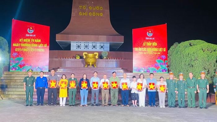  Thân nhân các anh hùng liệt sĩ nhận di ảnh được phục dựng. Ảnh: R'Piên 
