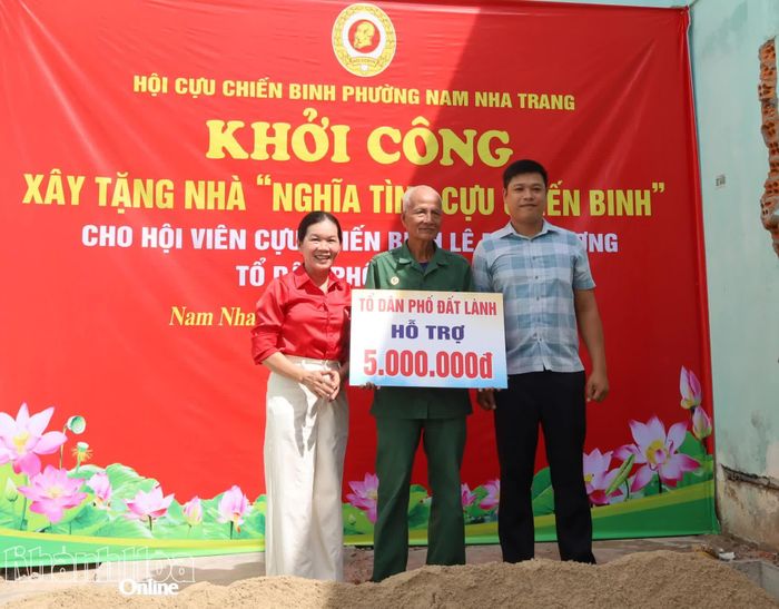 Đại diện Tổ dân phố Đất Lành trao bảng tượng trưng hỗ trợ cho gia đình.