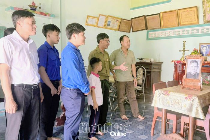 Các thành viên trong đoàn đến thăm, tặng ảnh đã phục hồi cho gia đình liệt sĩ Huỳnh Cầm.