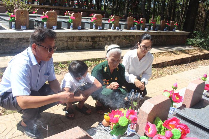 Bà Khổng Thị Tíu cùng con, cháu bên mộ liệt sĩ Khổng Minh Diện