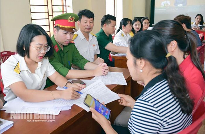 Cán bộ Thuế cơ sở 1 hướng dẫn, hỗ trợ chính sách thuế cho các hộ kinh doanh. Ảnh: Trường Giang