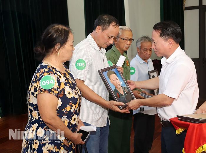 Lãnh đạo xã Bình Sơn trao di ảnh cho các gia đình liệt sĩ tại chương trình.