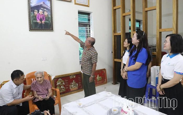 Ông Nguyễn Hùng Ngát tự hào giới thiệu hình ảnh hai người anh liệt sĩ với đoàn công tác của Hội Liên hiệp Phụ nữ tỉnh.