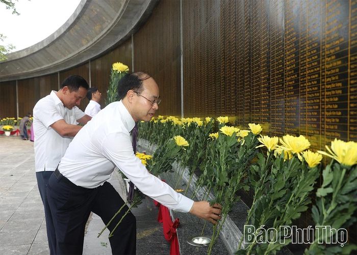 Các đại biểu dâng hoa tại bia ghi danh các Anh hùng liệt sĩ.