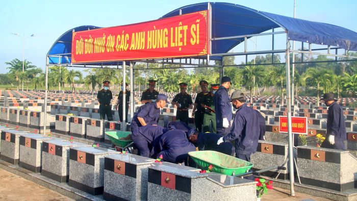 Lực lượng chức năng lấy mẫu sinh phẩm giám định ADN tại Nghĩa trang Liệt sĩ xã Phước Long.
