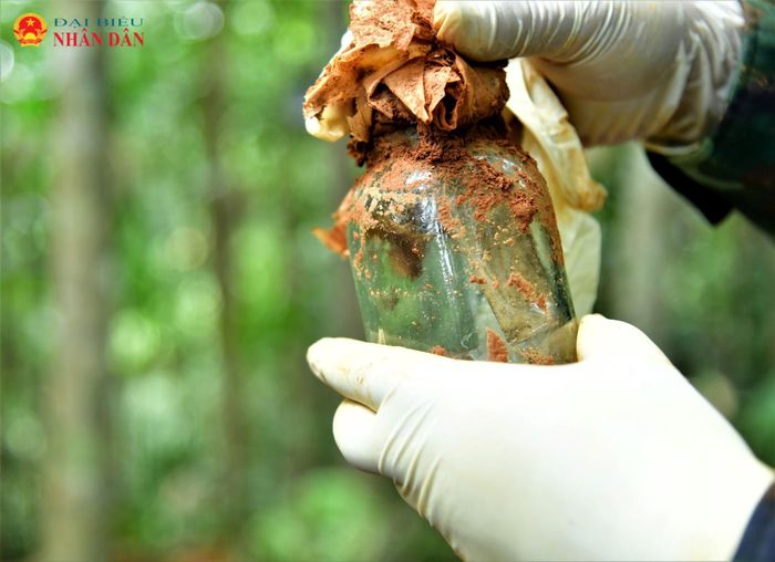 Bên trong lọ thủy tinh có thể chứa thông tin liệt sĩ vừa được Đoàn kinh tế Quốc phòng 337 Quân khu 4 tìm thấy ở hố chôn liệt sĩ tại khu vực đồi khe Cây Lỗi, thôn Cựp Cuôi, xã Hướng Lập