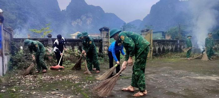 Cán bộ, chiến sĩ Đồn Biên phòng Cà Xèng phối hợp với đoàn viên, thanh niên địa phương chỉnh trang, vệ sinh khuôn viên Nghĩa trang Liệt sĩ Minh Hóa. Ảnh: Huy Thắng