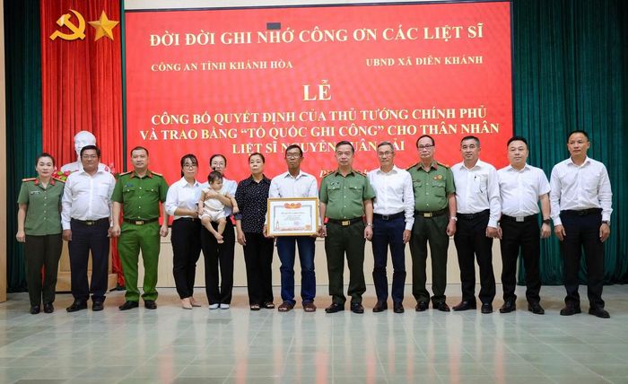 Thiếu tướng Nguyễn Hữu Phước, Giám đốc Công an tỉnh Khánh Hòa chụp ảnh lưu niệm cùng thân nhân liệt sĩ Nguyễn Xuân Hải và đại diện các cơ quan, cấp ủy, chính quyền địa phương xã Diên Lâm, xã Diên Khánh. Ảnh: Sơn Hồng.
