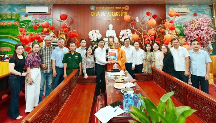 Chủ tịch Hội nhà báo tỉnh Nghệ An Trần Minh Ngọc tặng ấn phẩm báo cho Đại đức Thích Đồng Tuệ - Trụ trì chùa Da (Âu Lạc Cổ Tự). Ảnh: HQ