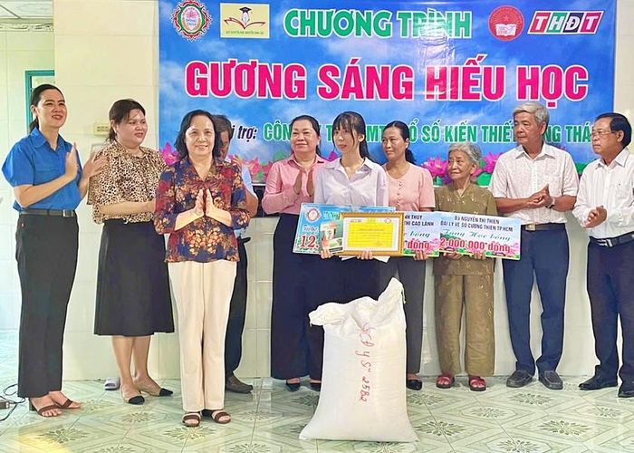 Chủ tịch Hội đồng quản lý Quỹ Khuyến học Nguyễn Sinh Sắc Nguyễn Thị Nhàn và các nhà hảo tâm trao tặng học bổng, phần quà cho em Bùi Thúy An.