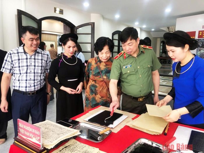 Bà Nông Thị Tố Hoàn, nguyên cán bộ Báo Việt Nam Độc lập, nguyên Phó Trưởng Ban Dân vận Tỉnh ủy Thái Nguyên (thứ 3 từ phải sang) hướng dẫn đại biểu trải nghiệm in Báo Việt Nam Độc lập và kể chuyện những ngày làm báo tại chiến khu Việt Bắc.