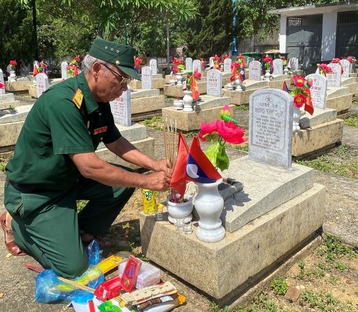 Thân nhân liệt sĩ thắp hương trước phần mộ tại nghĩa trang.
