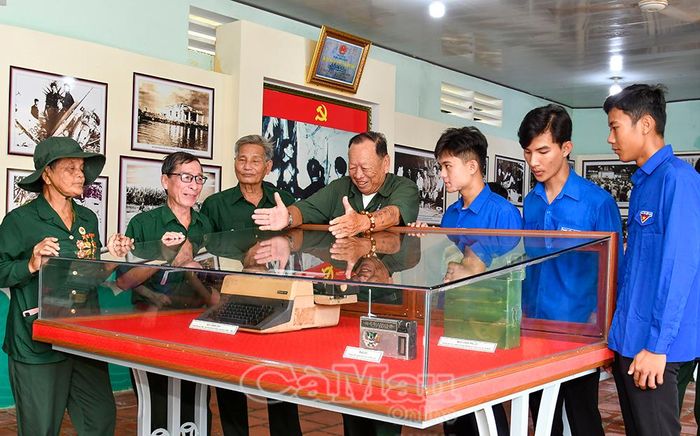 Các cựu chiến binh giới thiệu những kỷ vật lịch sử thời chiến cho đoàn viên, thanh niên trong chuyến về nguồn, giáo dục truyền thống cách mạng tại Khu Di tích Căn cứ Tỉnh ủy tại Xẻo Đước.