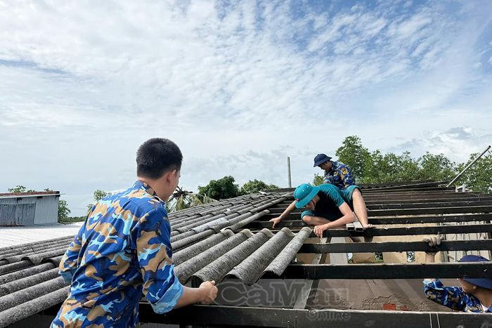 Cán bộ, chiến sĩ Lữ đoàn 175 cùng các lực lượng tháo dỡ phần mái nhà bị hư hỏng do dông lốc.