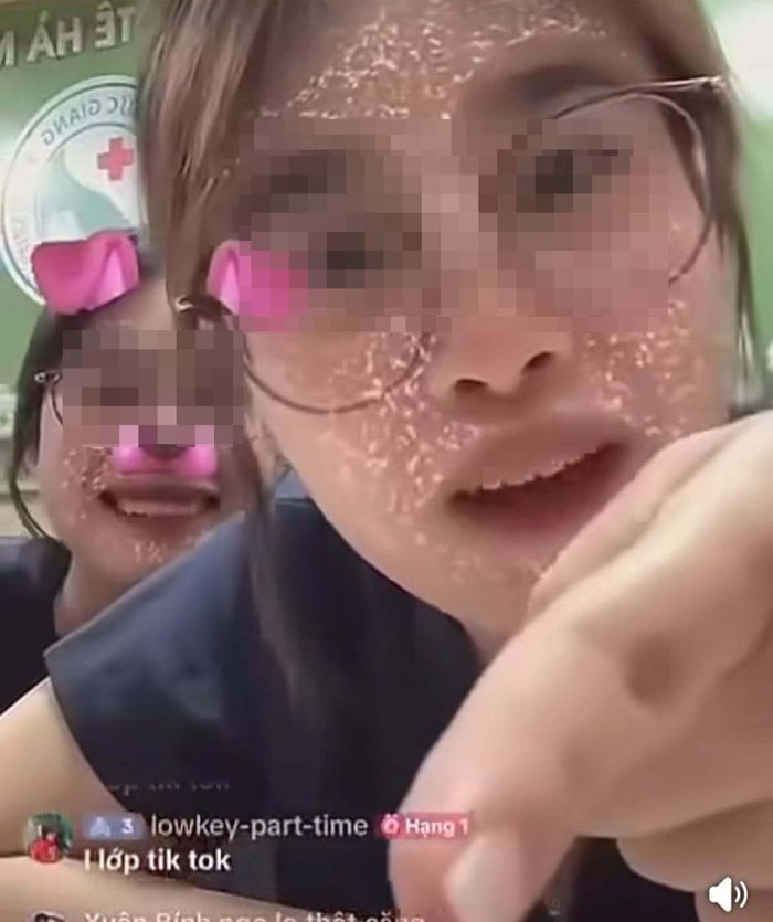Hai nữ sinh mặc đồng phục ngồi tại quầy lễ tân của Bệnh viện Đa khoa Đức Giang có những phát ngôn không đúng chuẩn mực trên mạng xã hội. (Ảnh: Chụp màn hình)
