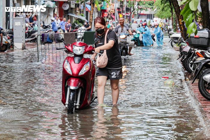 Nhiều xe bị chết máy, người dân phải dắt bộ để vượt qua các đoạn dềnh nước.