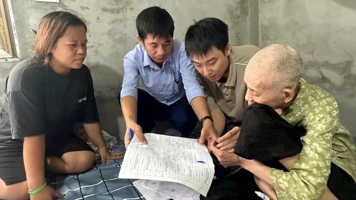 Phó Giám đốc Ban Quản lý dự án Đầu tư - Hạ tầng xã Thường Tín Đặng Văn Thành đến tận nhà hỗ trợ người dân hoàn thiện thủ tục nhận tiền bồi thường. Ảnh: PV
