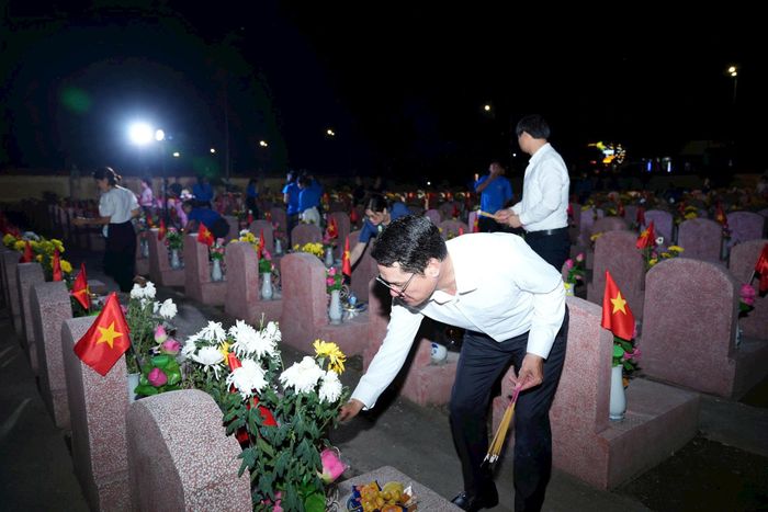 Ông Đào Đức Minh, Phó Bí thư Đảng ủy, Chủ tịch UBND xã thắp nến, tri ân các AHLS. Ảnh: Nguyễn Sơn