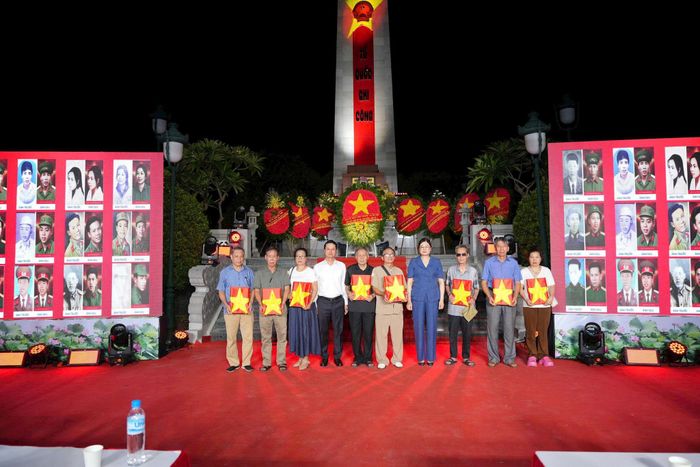 Bà Đặng Thị Huyền, Bí thư Đảng ủy, Chủ tịch HĐND xã trao tặng di ảnh liệt sĩ cho các thân nhân gia đình liệt sĩ. Ảnh: Nguyễn Sơn