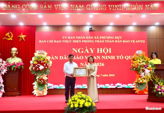 Phó Chủ tịch HĐND thành phố Hà Nội Phạm Thị Thanh Mai trao Bằng khen của Chủ tịch UBND thành phố Hà Nội cho Phó Chủ tịch UBND xã Phượng Dực Nguyễn Quang Huy. Ảnh: PN