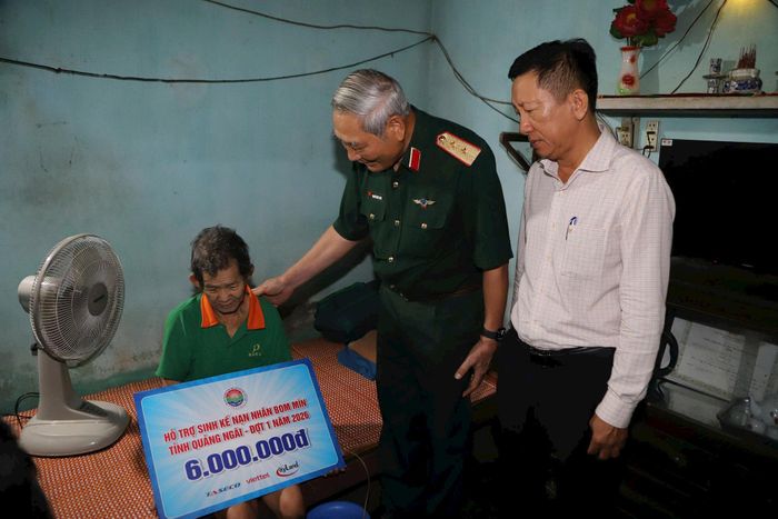 Trung tướng Nguyễn Đức Soát ân cần thăm hỏi nạn nhân bom mìn đã bị mất hai chân. Ảnh: Quỳnh Dương