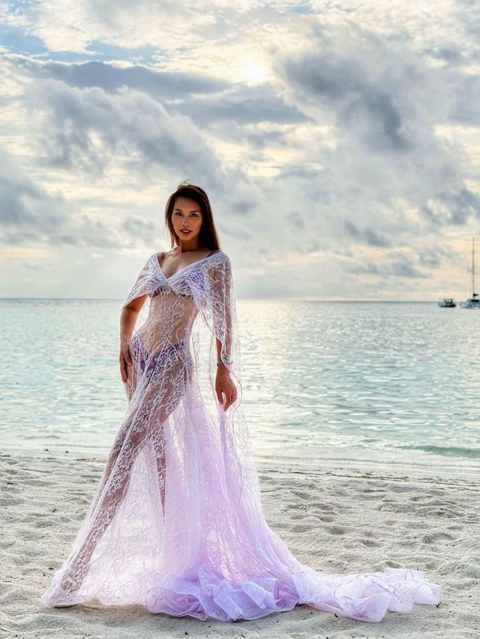 Siêu mẫu Hà Anh gây chú ý khi chia sẻ hình ảnh trong chuyến nghỉ dưỡng tại Maldives. Cô diện chiếc váy ren xuyên thấu mang gam màu trắng pha tím nhạt, kết hợp cùng đồ tắm tối màu bên trong. Thiết kế ôm sát tôn trọn đường cong quyến rũ và đôi chân dài trứ danh.