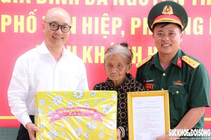 Ông Nguyễn Quốc Bảo – Bí thư Đảng ủy phường Ba Ngòi và Thượng tá Nguyễn Thành Chơn tặng quà cho bà Nguyễn Thị Tám. Ảnh: Duy Ngọc.