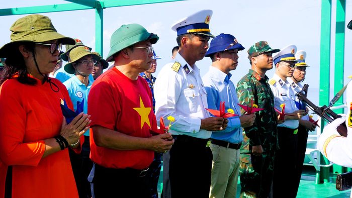 Trên tay mỗi người là một nhành hoa và hạc giấy... Ảnh: ML