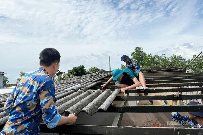 Cán bộ, chiến sĩ Lữ đoàn 175 cùng các lực lượng đưa các tấm lợp bị hư hỏng khỏi mái nhà. (Ảnh: Vùnng 5 - Hải Quân)