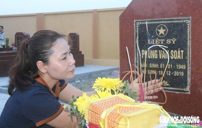 Người thân nghẹn lòng bên phần mộ liệt sĩ Phùng Văn Soát. Ảnh: Đức Tùy