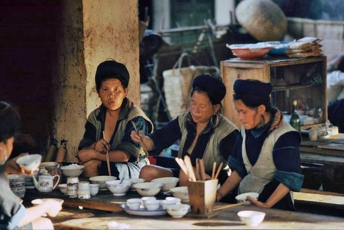  Grumpe ghi lại khoảnh khắc người H'Mông ăn sáng giữa phiên chợ vùng cao. Ông đặc biệt ấn tượng với những bộ trang phục nhuộm chàm thủ công, đôi khuyên tai bạc cỡ lớn của phụ nữ, tục cạo lông mày và chiếc khăn đội đầu màu đỏ đặc trưng của người Dao. 