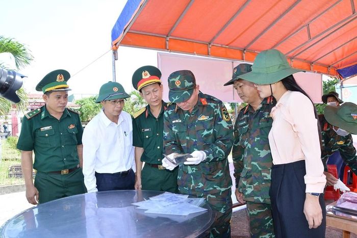 Đại tá Trịnh Công Sơn, Phó chính ủy Bộ CHQS tỉnh Quảng Ngãi và lãnh đạo địa phương cùng cơ quan chức năng kiểm tra số di vật an táng cùng liệt sĩ phát hiện được trong quá trình khai quật lấy mẫu