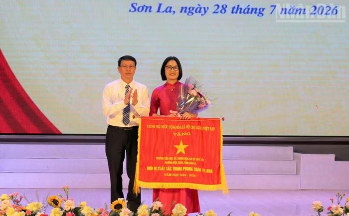 Đồng chí Giám đốc Sở Giáo dục và Đào tạo tỉnh Sơn La chuyển trao Cờ thi đua của Chính phủ cho Trường Tiểu học và Trung học cơ sở Tây Tiến, phường Mộc Châu.