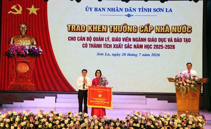 Ông Nguyễn Văn Chiến, Giám đốc Sở GD&amp;ĐT Sơn La chuyển trao cờ thi đua của Chính phủ cho Trường Tiểu học và THCS Tây Tiến, phường Mộc Châu.
