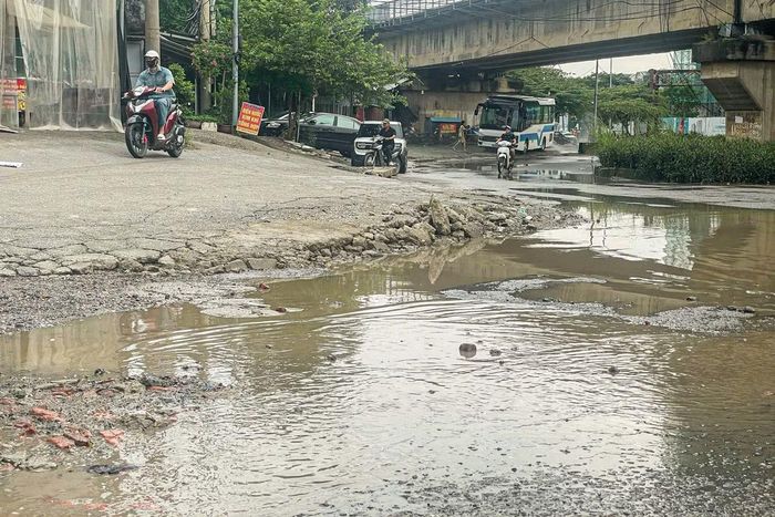 Xe máy leo lên vỉa hè, né đoạn đường chằng chịt ổ voi, ổ gà.