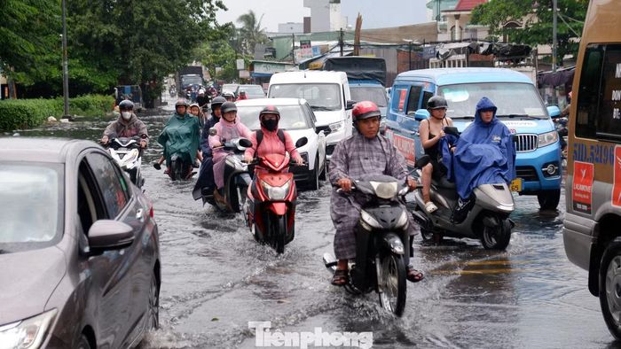 Các phương tiện nối đuôi nhau di chuyển chậm qua khu vực ngập nước trên đường Hồ Học Lãm trong giờ cao điểm chiều.