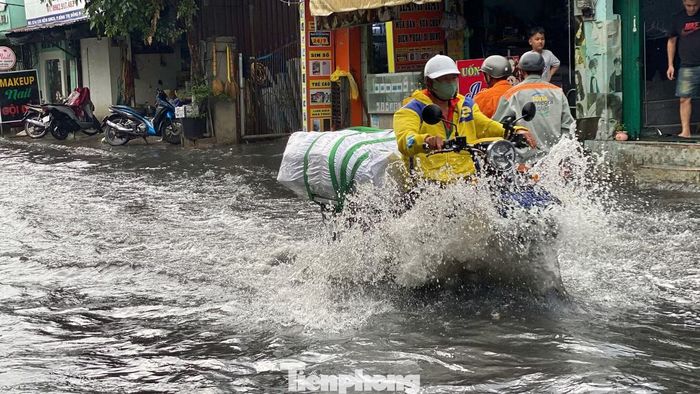 Mưa lớn chiều 28/7 khiến đường Sinco (phường An Lạc, TPHCM) ngập sâu, nhiều phương tiện di chuyển khó khăn.