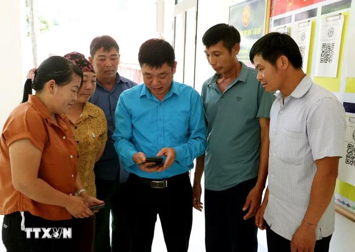 Cán bộ xã Lao Chải (Tuyên Quang) hướng dẫn người dân cài đặt, sử dụng các ứng dụng số và thực hiện thủ tục hành chính trên môi trường điện tử, từng bước thúc đẩy chuyển đổi số ở vùng biên. (Ảnh: Đức Thọ/TTXVN