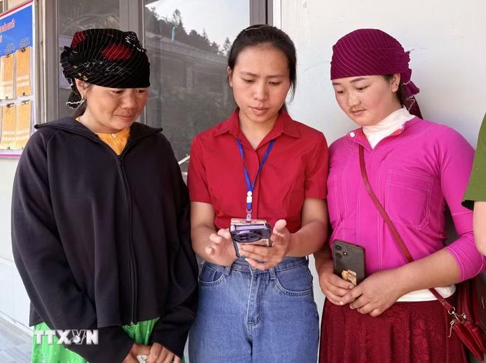 Cán bộ xã biên giới Lũng Cú (Tuyên Quang) hướng dẫn cho người dân thực hiện thủ tục hành chính qua công nghệ số. (Ảnh: Đức Thọ/TTXVN)