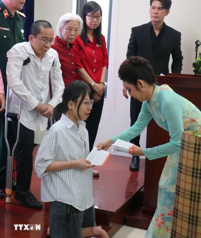 Đại diện Ban tổ chức tặng quà nạn nhân chất độc da cam/dioxin Thành phố Hồ Chí Minh. (Ảnh: Thanh Vũ/TTXVN)