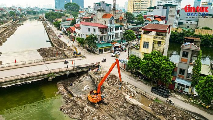 Máy xúc thi công tại vị trí tiếp giáp cầu, nơi có mặt bằng chật hẹp và đông dân cư.