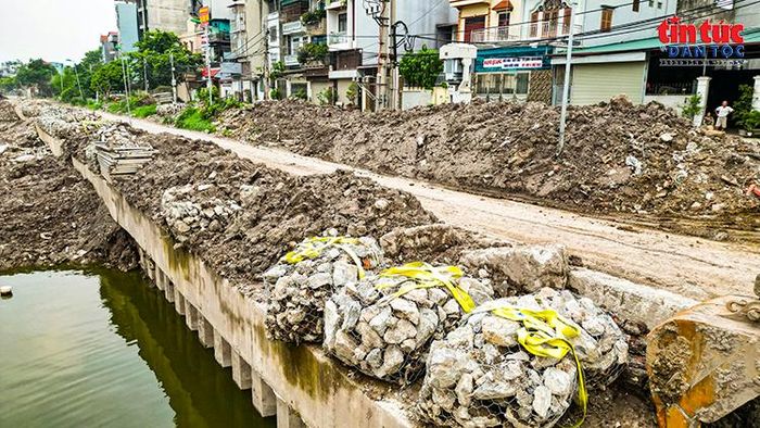 Vật liệu phục vụ gia cố mái và bờ sông được tập kết dọc tuyến công trình.