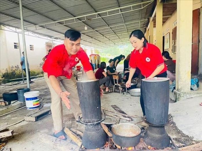Cán bộ Hội Chữ thập đỏ Việt Nam đồng hành cùng người dân tỉnh Nghệ An vượt khó. Ảnh: TTXVN phát