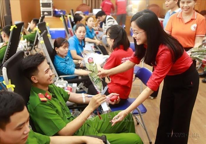 Phó Chủ tịch Hội Chữ thập đỏ tỉnh Vĩnh Phúc Nguyễn Thị Quỳnh Liên tặng hoa chúc mừng người hiến máu tình nguyện tại Ngày hội hiến máu tình nguyện “Những trái tim Hồng”. Ảnh: Hoàng Hùng/TTXVN