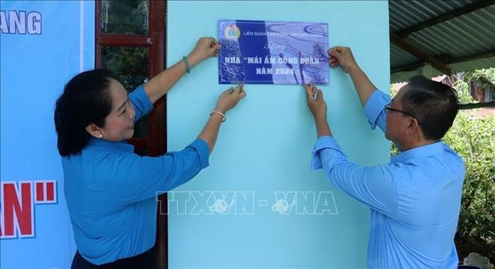 Chủ tịch Công đoàn ngành Giáo dục Kiên Giang (cũ) Lâm Thị Mạnh gắn biển nhà “Mái ấm Công đoàn” cho đoàn viên. Ảnh: Lê Huy Hải/TTXVN