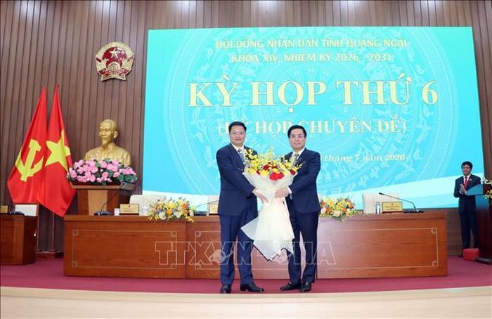 Ông Nguyễn Hoàng Giang, nguyên Chủ tịch UBND tỉnh Quảng Ngãi, tặng hoa chức mừng ông Nguyễn Đức Tâm (bên trái), tân Chủ tịch UBND tỉnh nhiệm kỳ 2026-2031.