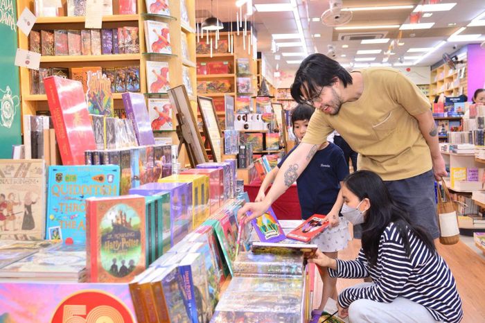Phụ huynh đưa con em đi tham khảo các bộ sách hỗ trợ học tiếng Anh.
